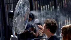 Ljudi se rashlađuju ispred ventilatora tokom toplih dana