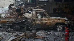 Halep'te Kürt silahlı güçlere ait yanmış bir pikap araç. Aracın üzerinde ağır silah teçhizatı görülüyor. 