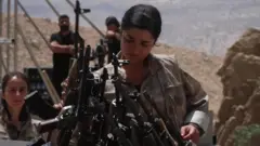 A woman places a gun into a cauldron