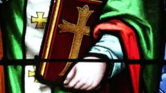 Uma imagem em vidro de uma mão segurando a bíblia