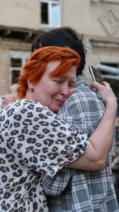 ljudi se grle i teše u kijevu posle napada rusije 