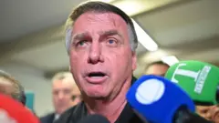 O ex-presidente brasileiro Jair Bolsonaro fala à imprensa após o almoço e uma visita aos líderes do Partido Liberal (PL) no Senado Federal em 18 de fevereiro de 2025