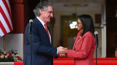 El secretario del Interior de Estados Unidos, Doug Burgum, y la presidenta encargada de la República Bolivariana de Venezuela, Delcy Rodríguez, mirándose de frente y dándose la mano el 5 de marzo de 2025 en el palacio de Miraflores, Caracas, Venezuela. (Foto: Federico PARRA / AFP vía Getty Images)