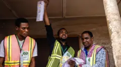 An Independent National Electoral Commission (INEC) official holds up a ballot paper during the counting process at a polling station