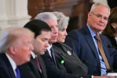 Donald Trump hablando y a lo lejos lo ve el presidente de ExxonMobil, Darren Wood