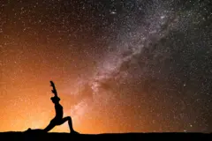 Pessoa fazendo ioga com céu estrelado ao fundo