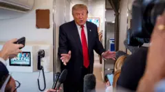 ABD Başkanı Donald Trump, 27 Temmuz 2026'da Michigan'a yaptığı yolculuk sırasında Air Force One uçağında gazetecilere konuşuyor.  Andrew Harnik/Getty Images)