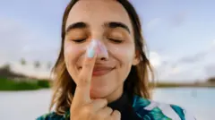 Una mujer se coloca protector solar en la nariz 