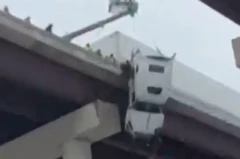 Caminhão pendurado em ponte 