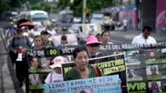 Grupo de mulheres empunhando cartazes que pedem libertação de seus filhos.