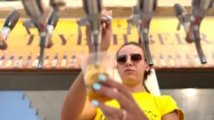 سيدة تسكب البيرة في كأس