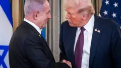 Trump e Netanyahu apertam as mãos e sorriem