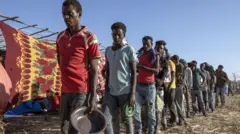 በመስራቅ ሱዳን ባለ የስደተኞች መጠለያ ጣቢያ ምግብ ለመቀበል የተሰለፉ የትግራይ ተወላጆች ታኅሣሥ 3/2013 ዓ.ም. 