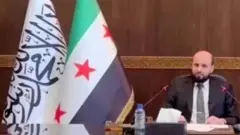 या फोटोत सीरियाच्या हंगामी पंतप्रधानांच्या बैठकीत पांढरा झेंडा दिसत आहे.