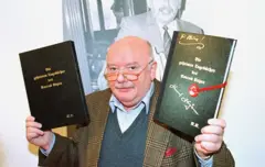 Durante seu julgamento, o falsificador de arte Konrad Kujau mostra um dos diários de Hitler que ele falsificou. Em 1984, um tribunal de Hamburgo condenou Kujau a quatro anos e meio de prisão pela falsificação.