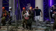 Una mujer es rescatada de un edificio en Israel tras un ataque iraní.
