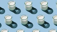Soluk mavi bir arka plan üzerinde çapraz çizgiler halinde dizilmiş küçük kefir bardakları.
