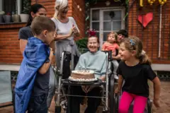 Idosa comemorando 100 anos de idade no quintal de casa com a família