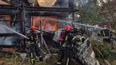 Bomberos retiran escombros e intentan apagar las llamas en un edificio en Ucrania, 21 de agosto de 2025