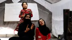 مونا علی‌الکریم می‌گوید که او و دخترانش برای پرداخت هزینه درمانی بیمارستان گدایی می‌کنند