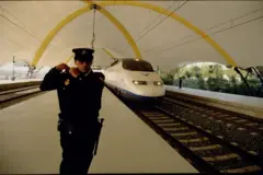 Um policial espanhol, ao lado de um trem da primeira linha de alta velocidade (Madri-Sevilha), inaugurada em 1992