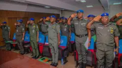 Cross section of senior officers of di Nigeria police wearing their kaki uniforms and blue baret and giving salute