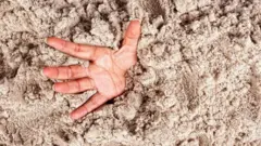 Main dans le sable
