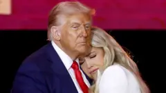 US President Donald Trump (L) and Erika Kirk (R), wife of Charlie Kirk, embrace on stage during the public memorial service of political activist Charlie Kirk at State Farm Stadium in Glendale, Arizona, USA, 21 September 2025.