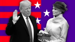 Donald Trump, mặc vest và thắt cà vạt, đặt tay lên một cuốn Kinh Thánh do vợ ông, Melania Trump, cầm. Họ đứng trước phông nền có các sọc đỏ và ngôi sao trắng trên nền tím.