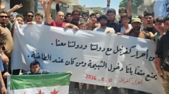 تجمع مردم با پارچه‌نوشت بزرگی در دست