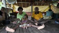 Keluarga Maurenus Merne tinggal di Kampung Anggreso, Kabupaten Mamberamo Raya. Anak bungsunya, Petra, lumpuh sejak balita dugaannya selama mengandung, mama Ester tidak mendapatkan asupan makanan bergizi dan vitamin yang memadai.