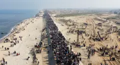 Uma longa fila de pessoas voltando para suas casas bombardeadas no norte de Gaza em janeiro.