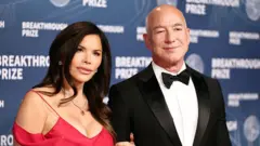 Lauren Sanchez and Jeff Bezos on a red carpet at an event.