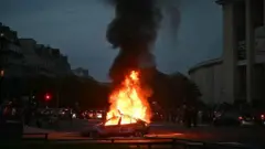 سيارة مشتعلة في ساحة تروكاديرو بباريس وسط احتفالات جماهير باريس سان جيرمان عقب تتويج الفريق بلقب دوري أبطال أوروبا، 30 مايو/أيار 2026.