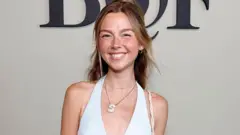 Towle, wearing a white top, smiling very big