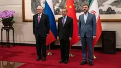O ministro das Relações Exteriores da China, Wang Yi (centro), recebe seu homólogo russo, Sergei Ryabkov (esq.) e o vice-ministro das Relações Exteriores do Irã, Kazem Gharibabadi, em Pequim, no dia 14 de março de 2025