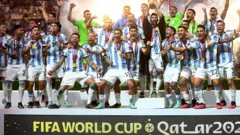 Lionel Messi celebra o título da Copa do Mundo com o troféu e seus companheiros da seleção argentina