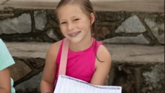 Renee Smajstrla usa uma blusa rosa e sorri