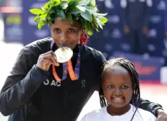 'Yar wasan tsere daga Kenya tare da 'yarta yayin da ta yi nasara a tseren mata da aka gudanar a birnin York City.