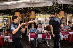 La terraza de un bar y dos camareros.