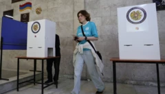 Ermenistan seçimlerinde bir kadın az önce oy vermiş ve kapalı bir yerde ayrılıyor. Elinde oyunu tutuyor, üzerinde forma gibi bir kıyafet var.