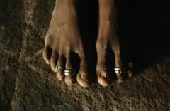 ANDHRA PRADESH, INDIA - AUGUST 23: Yellama, 31, wears toe rings which signify that she is married to the goddess she has been named after in her home in this photo taken on August 23, 2005 in Mehbubnagar, in Andhra Pradesh, India. She is a Jogini, or "servant of god" and was married off to the local deity when she was seven years old because her parents did not have a male child to support them . They believed it was better to keep her in their village and the only way to do this is to marry her to the goddess. After the cermony she is unable to marry any man and becomes the property of the men in the village. On the night of her initiation, after reaching puberty, the joginis are offered to an upper caste village elder or landlord. As months and years go by, most of the men in the village end up exploiting these girls. Jogini, Mathamma, Basiviin different regions of Andhra Pradesh they go by different names but they are all variations of a similar tradition of sexual exploitation of poor, illiterate Dalit women in the name of religion. The practice dates back some 2,000 years and is still deeply ingrained in the local Telangana culture. (Photo by Ami Vitale/Getty Images)