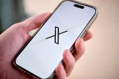 Mão segura telefone aberto no X