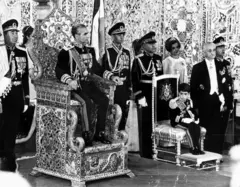 Coroação de Mohammad Reza Pahlavi (1919-1980) como Xá do Irã, com a Rainha Farah Pahlavi à esquerda e Reza Pahlavi, Príncipe Herdeiro do Irã, à direita.