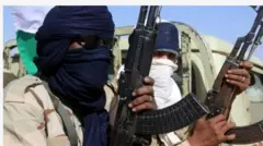 Aworan awọn agbebọn meji to gbe ibọn dani ti wọn si bo oju wọn