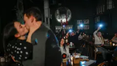 Пара цілується в барі під час відключення електроенергії в Києві 24 листопада 2022 року, 
