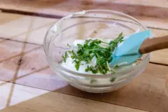 یک کاسه کوچک ماست با مقداری سبزیجات روی آن