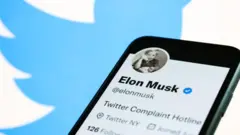 Ifoto yafatanyijwe igaragaza telefone ngendanwa iriho konti ya Twitter ya Elon Musk, n'ikirango cya Twitter kiri inyuma yayo