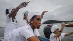 Fiéis do candomblé fazendo oferendas a Iemanjá na Baía da Guanabara, em São Gonçalo, no Rio de Janeiro, em fevereiro de 2019