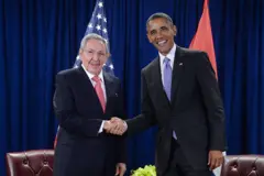 Raúl Castro e Obama dando um aperto de mão e sorrindo para as fotos